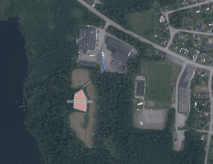 Karta som visar aktuell planområde i västra Rörvik för fastigheten Håknatorp 1:29 med ortofoto från Lantmäteriet som bakgrund som visar badplatsen, skogen och mindre åkrar.